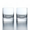 Two clear glass tumblers on a reflective surface with a white background
