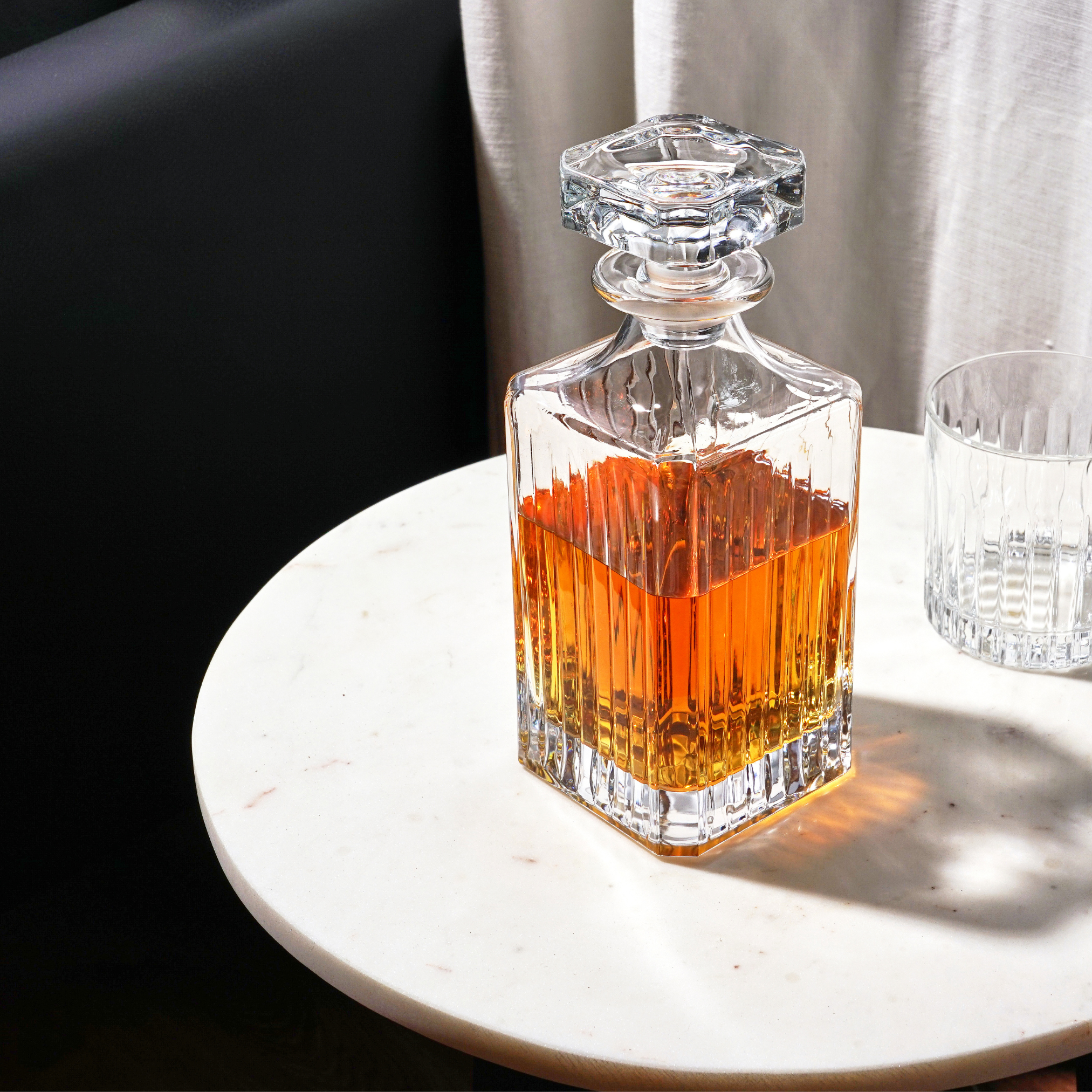 Glass decanter with layered liquid on a marble surface