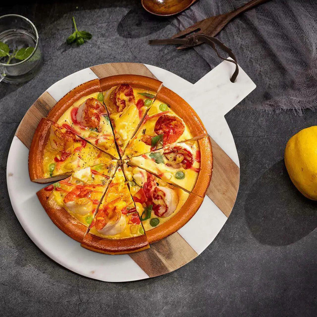 Pizza on a wooden and marble board on a dark surface.