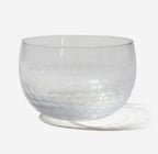 Clear glass bowl with textured surface on a white background