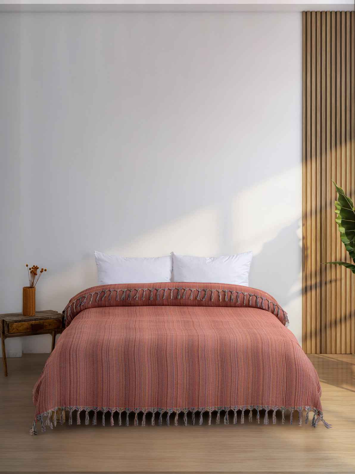 Orange king size blanket with tassels on a modern bed in a minimalist bedroom