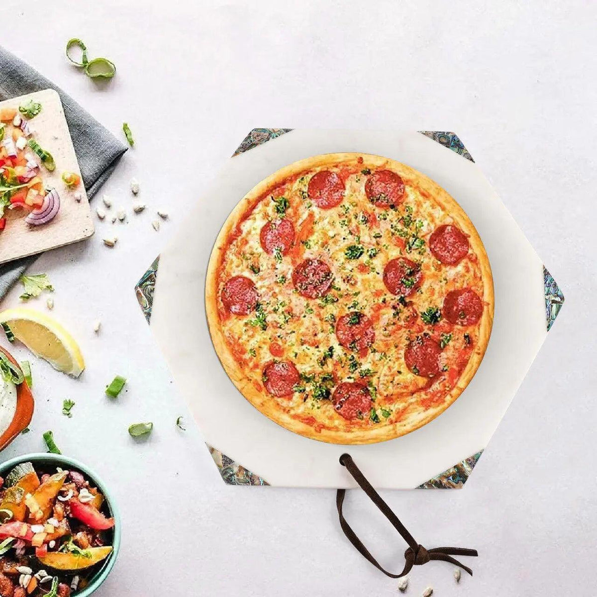Pepperoni pizza on a white surface with side dishes