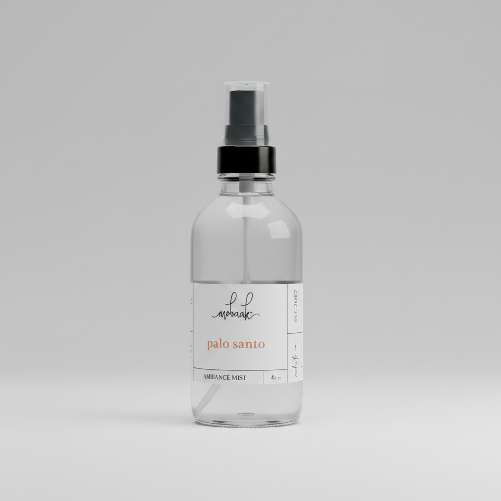 Clear glass bottle with black spray nozzle on a gray background