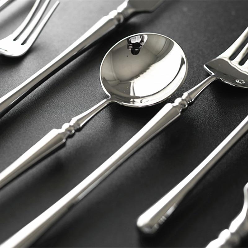 Silver spoon and fork set on a dark surface