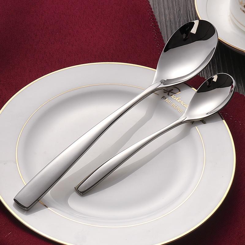 Silver cutlery set on a white plate with a red napkin in the background.