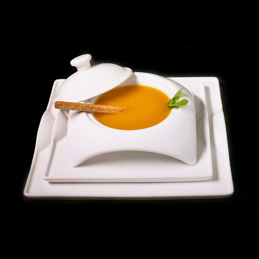 Modern square white dinnerware set with soup bowl, breadstick, and mint garnish on black background