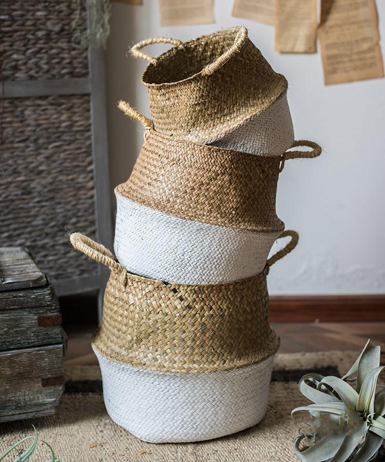 Stack of woven baskets with natural and white finish on a wooden surface.