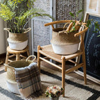 Woven baskets with plants and a blanket on a wooden chair in a home setting.