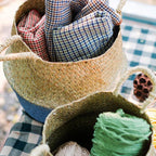 Woven basket with checkered fabric and yarn on a checkered surface