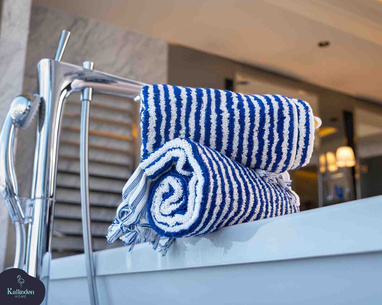 Blue and white striped jacquard hand towels with fringes on a bathtub in a modern bathroom