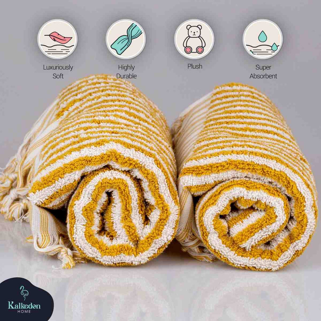 Yellow and white striped jacquard hand towels rolled up, plush, soft, and absorbent.