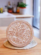 Decorative ceramic plate with bird design on a wooden surface