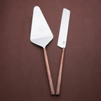 Two spatulas with copper handles on a brown background