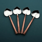 Four spoons with copper handles on a dark green background