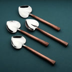 Set of four spoons with copper handles on a dark green background