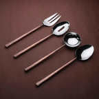 Set of four silver spoons and forks with wooden handles on a brown background