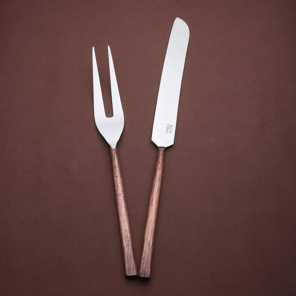 Sundance meat carving knife and two-tined fork with textured copper-toned handles, angled together on a brown background.