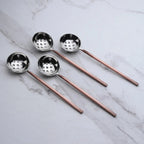 Set of four ladles with metal handles on a marble surface