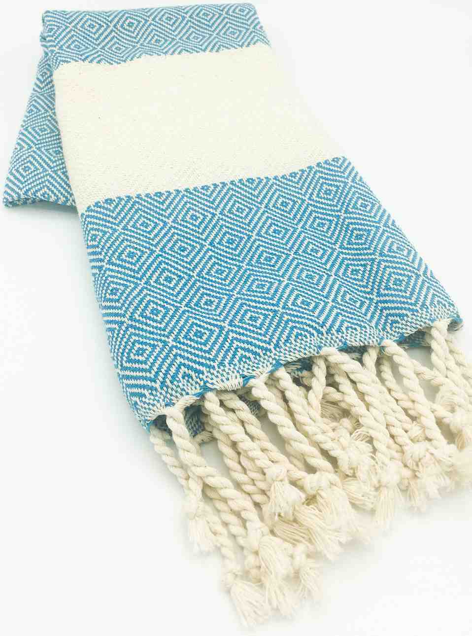 Folded turquoise diamond pattern hand towel with white fringed tassels on white background