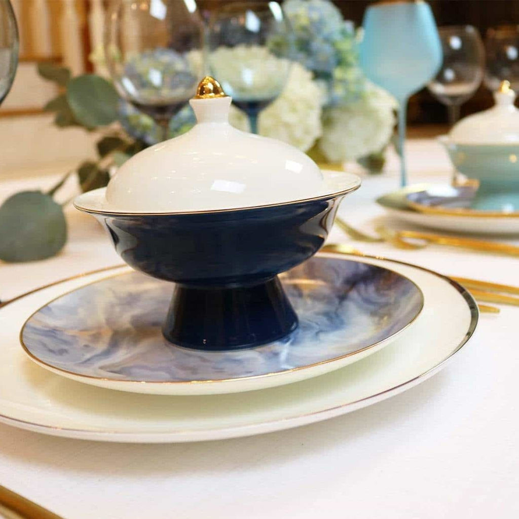 Elegant navy and white porcelain dinnerware with gold rim on a set dining table