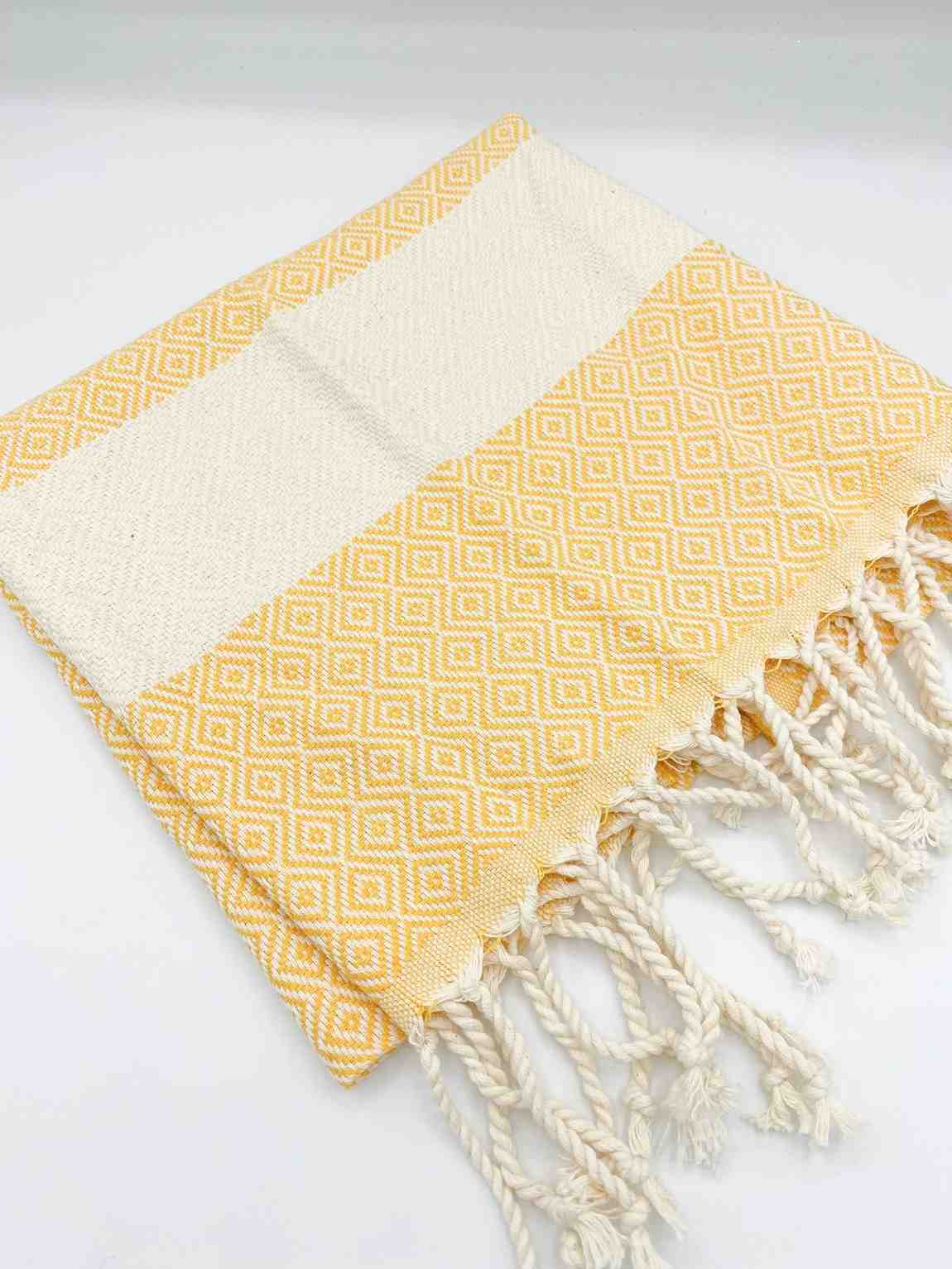 Yellow diamond patterned hand towel with fringe, modern home decor linen on white background
